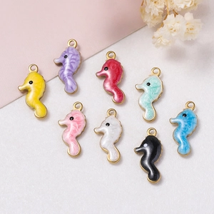 Détail macro de huit breloques hippocampes en émail coloré avec boucles en métal doré