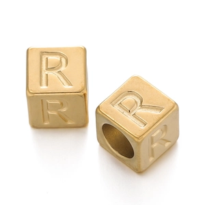 Detailed macro view of gold-plated square alphabet bead with engraved letter R
