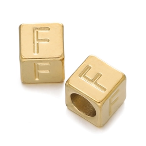 Macro shot of 7mm golden stainless steel cube beads with letter F engraving for DIY jewelry