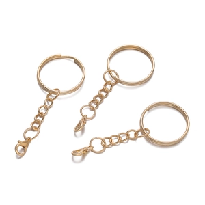 Three light gold lobster clasps with flat key rings and chains on white background