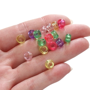 Détail macro de perles acryliques transparentes colorées de 4x7mm pour bijoux DIY