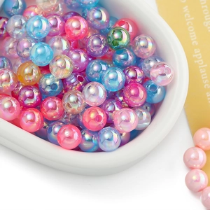 Macro shot of colorful iridescent AB round beads in a white tray for DIY crafts