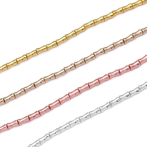 Nahaufnahme von bambusförmigen Hämatitperlen in Gold, Silber und Roségold