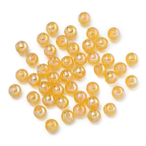 Detail of yellow iridescent round acrylic beads with holographic finish for DIY crafts