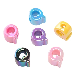 Dettaglio macro di perle in acrilico placcato UV lettera Q multicolore per gioielli DIY
