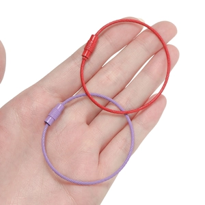 Detail of red and purple coated wire keychains with knurled screw connectors in hand