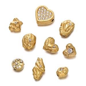 Détail de perles cœur et arbre de vie dorées avec incrustation de cristaux brillants