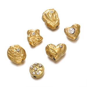 Vue détaillée de perles coeur dorées avec cristaux pour la création de bijoux