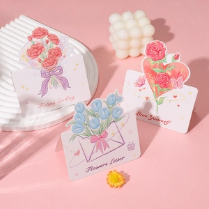 Nahaufnahme kreativer Grußkarten mit Rosen- und Tulpenillustrationen für Feste