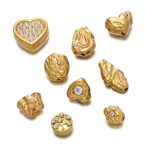 Détail de perles d'espacement dorées avec motifs de cœurs évidés et strass pour bijoux DIY