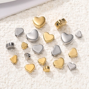 Makroaufnahme von Gold- und Silber-Edelstahl-Herzperlen für DIY-Schmuckherstellung