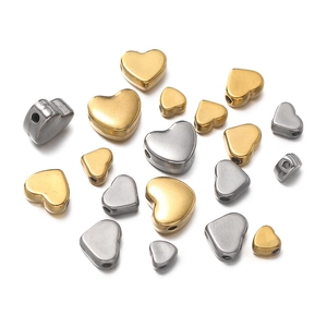 Makroaufnahme von herzförmigen Edelstahperlen in Gold und Silber für DIY-Schmuckherstellung