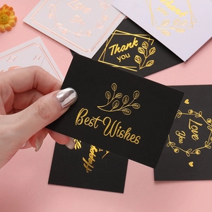 Detail of elegant gold foil greeting cards with floral borders and Best Wishes lettering