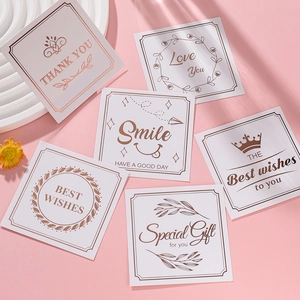 Close-up of gold-stamped 'Thank You' cards with mini flowers and aesthetic props