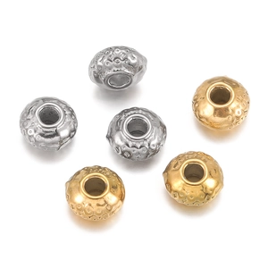 Macro-opname van gehamerde roestvrijstalen kraaltjes in goud en zilver voor DIY sieraden