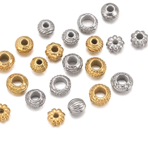 Detailweergave van getextureerde gouden en zilveren roestvrijstalen kralen voor DIY-sieraden
