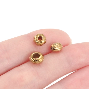 Drie gouden roestvrijstalen tussenkralen met bloem- en streepmotieven voor DIY-sieraden