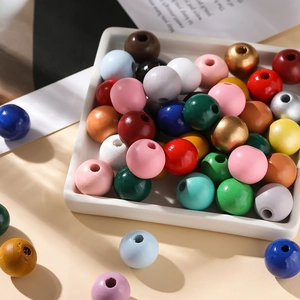 Mélange de perles en bois colorées de 16mm avec grands trous dans un plateau blanc