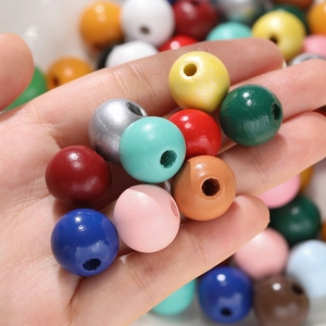 Vue macro de perles rondes en bois colorées de 16mm avec trous percés pour bijoux DIY