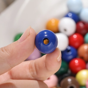 Vue macro de perles rondes en bois colorées 16mm pour la création de bijoux DIY