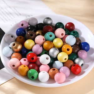 Perles en bois colorées de 16mm polies dans un plateau pour la création de bijoux DIY