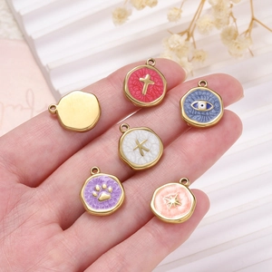 Detail of colorful enamel charms including Evil Eye and Star motifs held by hand
