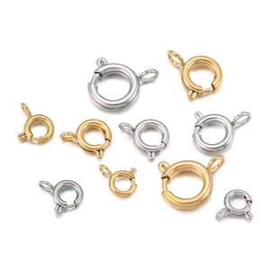 Close-up of golden and silver stainless steel spring ring clasps in various sizes for jewelry