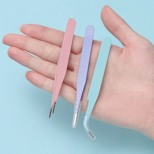 Jeu de trois pincettes en acier inoxydable aux couleurs macaron tenu dans la main