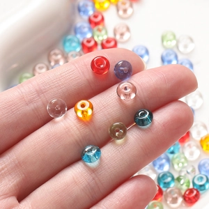 Macro shot of 3x6.5mm colorful glass beads held by hand for DIY jewelry making