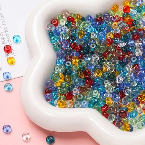 Close-up of colorful 3x6.5mm flat glass beads for DIY jewelry making in a white ceramic dish