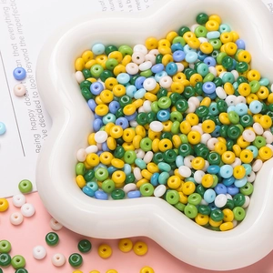 Close-up of colorful 3x6.5mm glass beads in a flower bowl for DIY jewelry making
