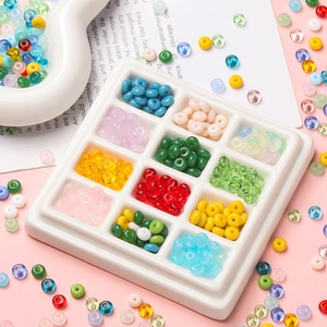 Flat round glass beads in 12 colors organized in a white tray for DIY jewelry making