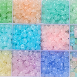 Close-up of multi-colored flat round glass beads stored in a grid organizer box