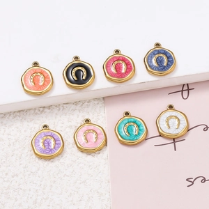 Macro detail of horseshoe enamel pendants in various colors for DIY jewelry making