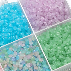 Close-up of assorted macaron colored 3x6.5mm glass beads in a clear plastic organizer