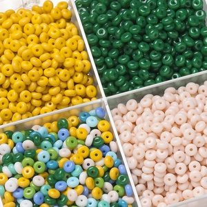 Close-up of colorful 3*6.5mm glass abacus beads organized in a grid storage box