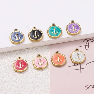 Detail of colorful nautical anchor charms with enamel finish and gold scalloped edges