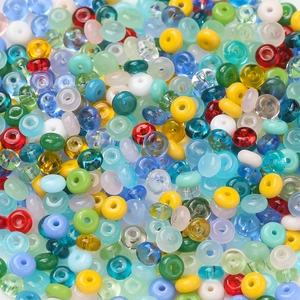 Macro detail of mixed color glass beads showing translucent and matte textures for DIY