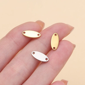 Macro view of small stainless steel oval tags with double holes for DIY jewelry making