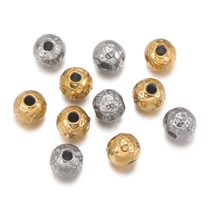 Macro detail of textured 18k gold and silver stainless steel beads with hammered finish