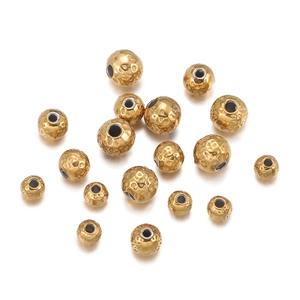 Macro detail of gold 18k plated stainless steel beads with hammered texture and drill holes