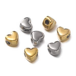 Close-up of polished gold and silver heart-shaped spacer beads for DIY jewelry making