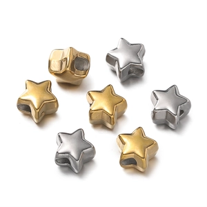 Macro view of polished star-shaped stainless steel beads in gold and silver finish