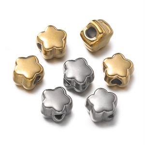 Detailed view of gold and silver star-shaped spacer beads with holes for DIY jewelry