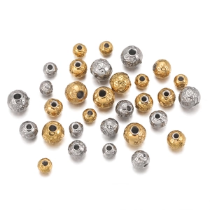 Detailed macro view of 18k gold and silver plated hammered metal beads for DIY jewelry