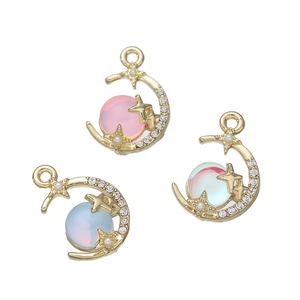 Dettaglio di ciondoli a forma di luna e stella con perle iridescenti per gioielli fai da te
