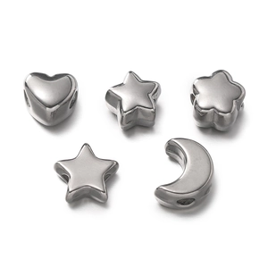 Detailed macro of stainless steel spacer beads in heart, star, and moon shapes for DIY jewelry