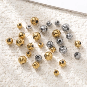 Macro view of textured 18k gold and silver stainless steel beads for DIY jewelry making
