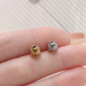 Macro shot of gold and silver hammered stainless steel beads with holes for DIY jewelry