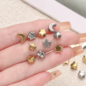 Close-up of assorted gold and silver stainless steel beads in star and heart shapes
